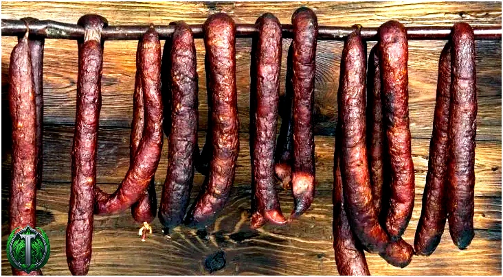 Багато коричневих ковбас, що звисають з жердини