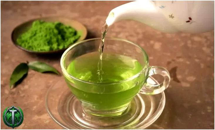 Гарячий чайник, з якого заварюють зелений чай у чашку