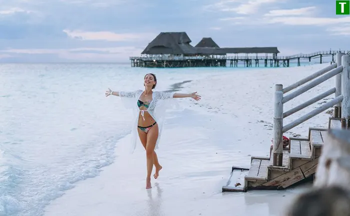 Ідеальний пляжний відпочинок на Мальдівських островах Відпочинок на Мальдівах - жінка на пляжі з білосніжним піском та прозорою блакитною водою